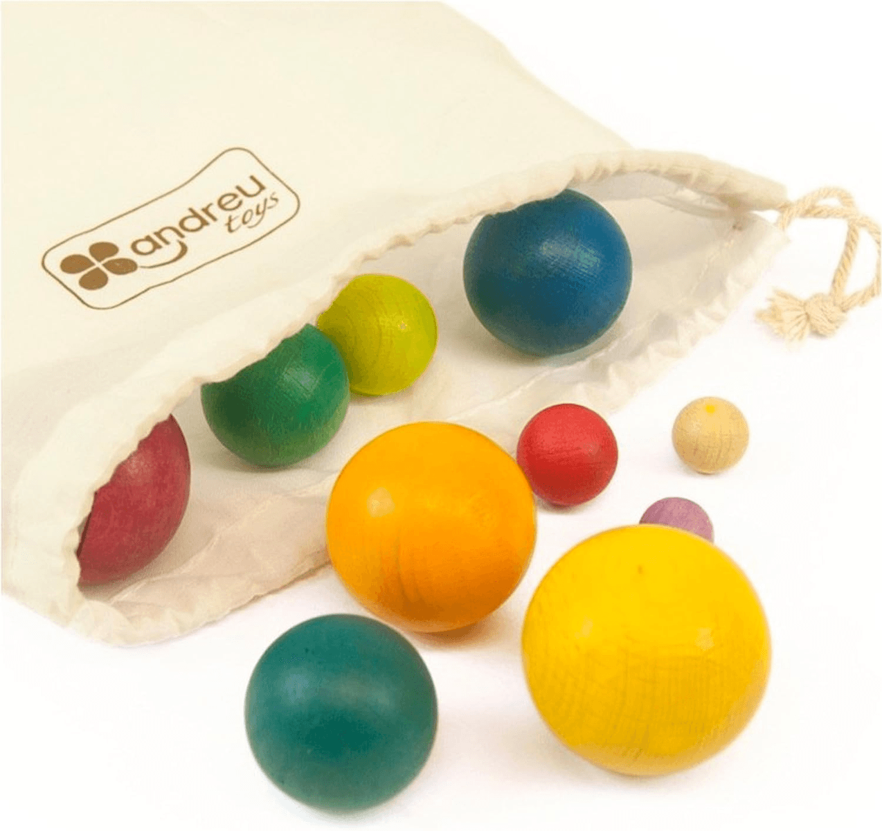 Bolas de madera de colores salen de una bolsa de tela beige de Andreu Toys sobre una superficie blanca.