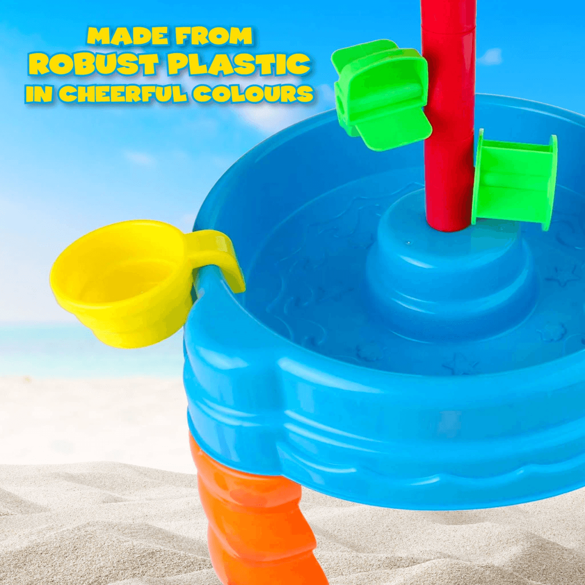 Colorido juguete de agua de plástico con poste rojo y cuenco azul en la arena.