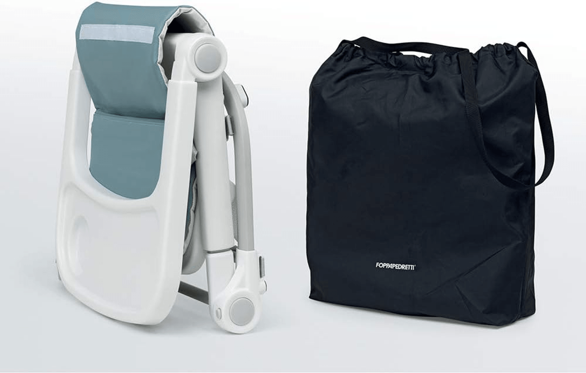 Una silla alta plegada azul y blanca junto a una bolsa de transporte negra sobre fondo claro.