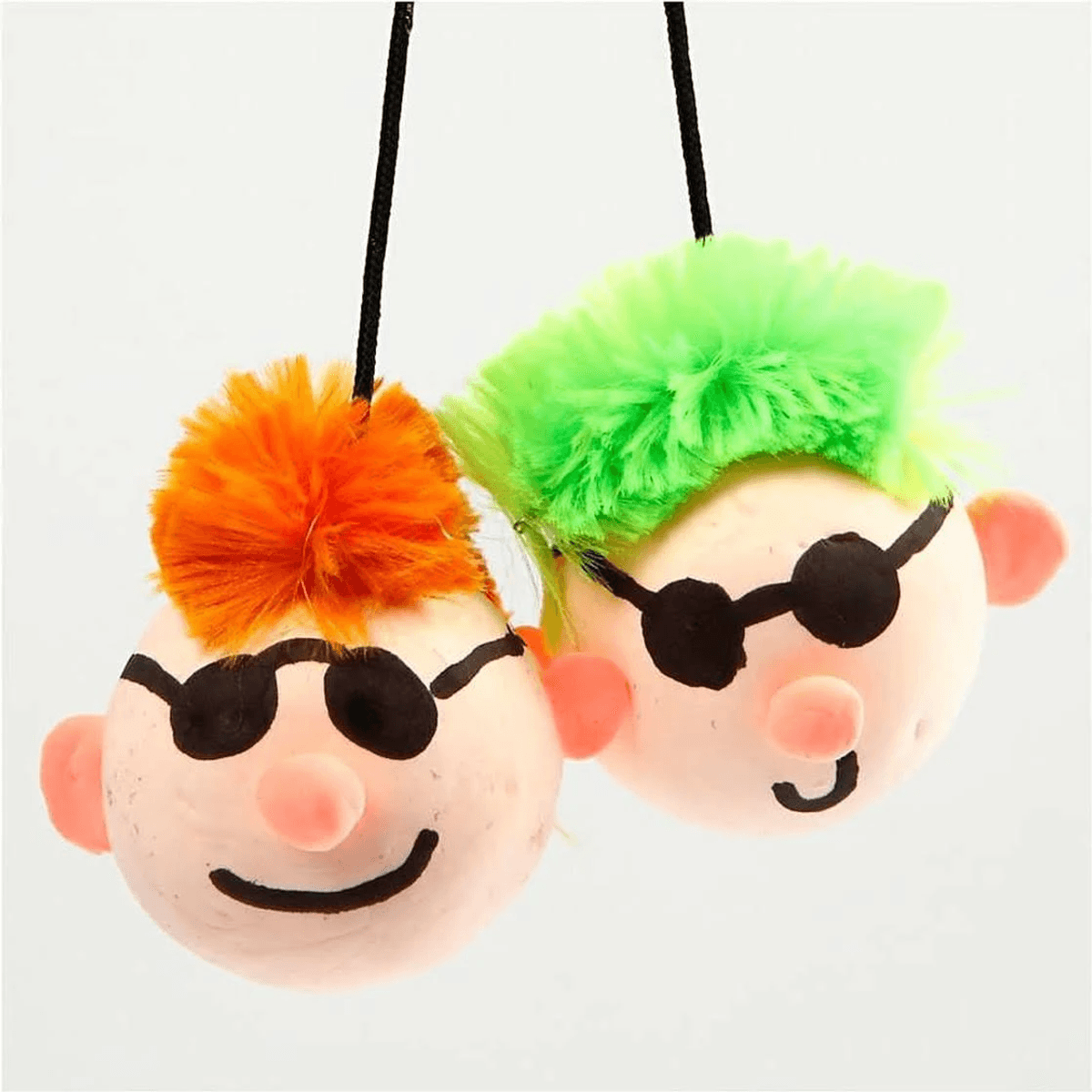 Dos pelotas antiestrés colgantes con caras pintadas, gafas de sol y pelo de felpa de colores.
