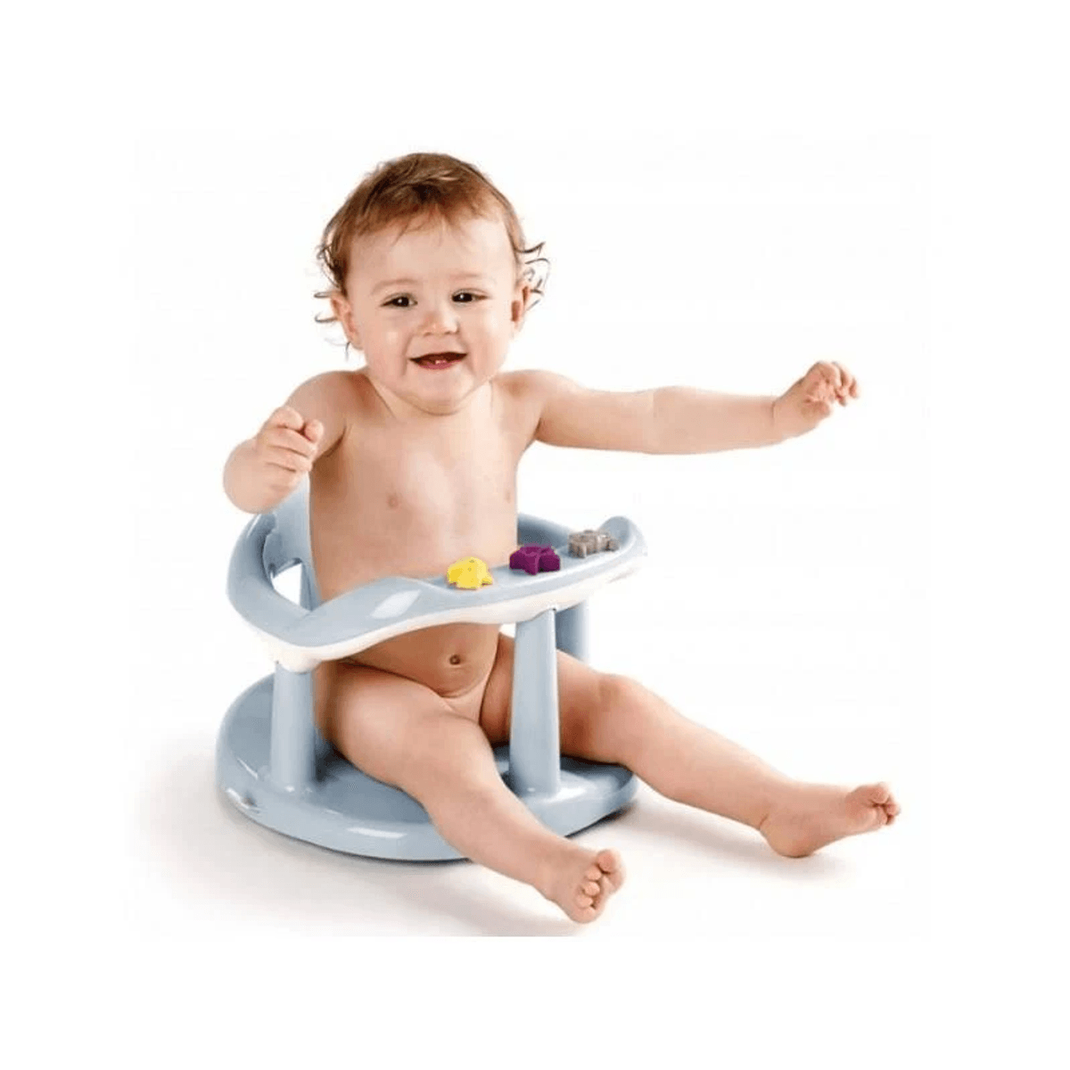 Un bebé feliz sentado en un asiento de baño de plástico azul con juguetes coloridos sobre fondo blanco.