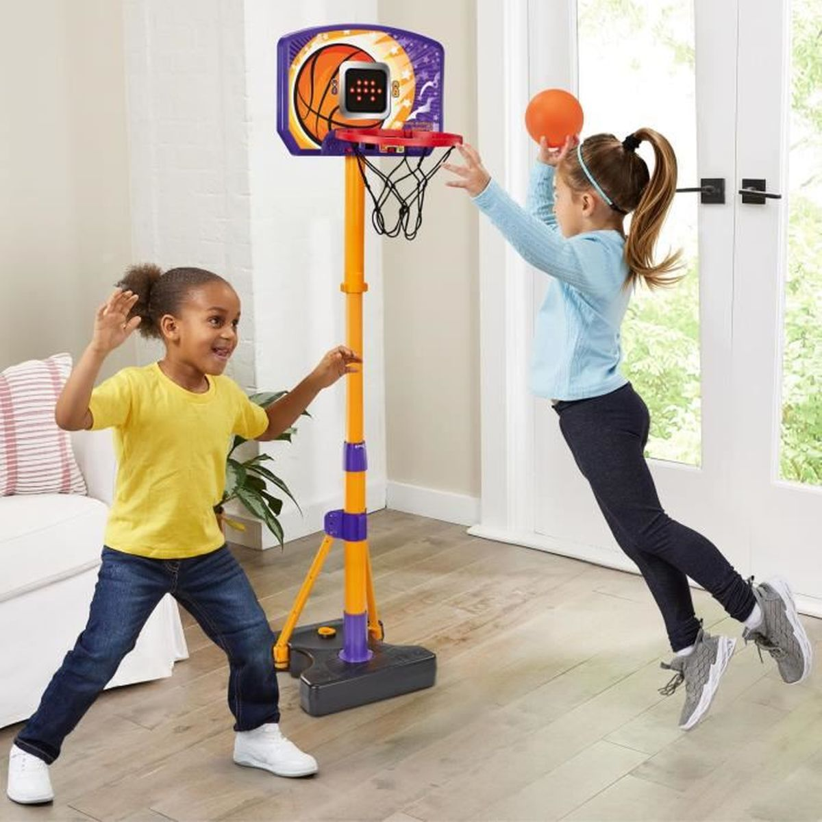 Due bambini che giocano a basket in un soggiorno.