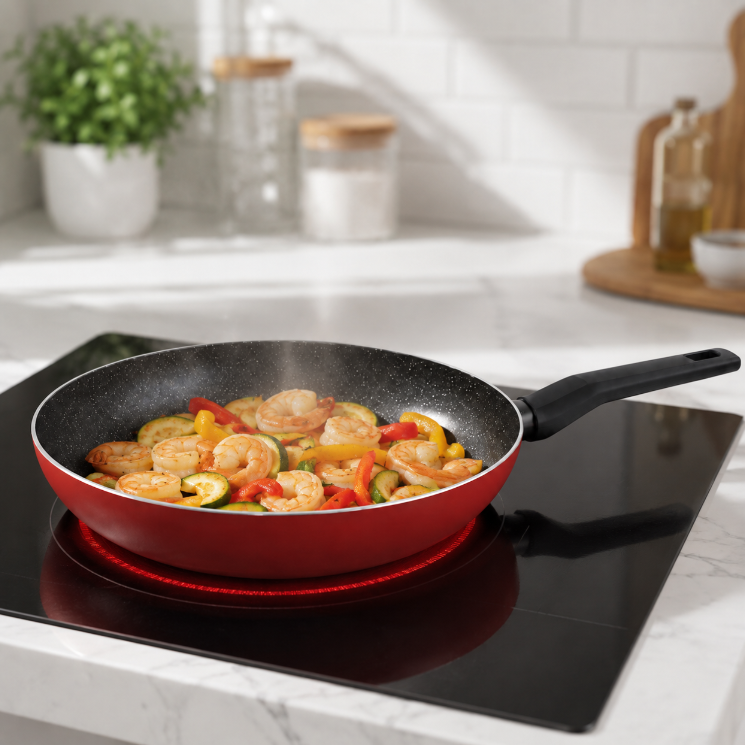 Una padella rossa su un piano cottura a induzione nero cuoce gamberi, zucchine e peperoni in una cucina.