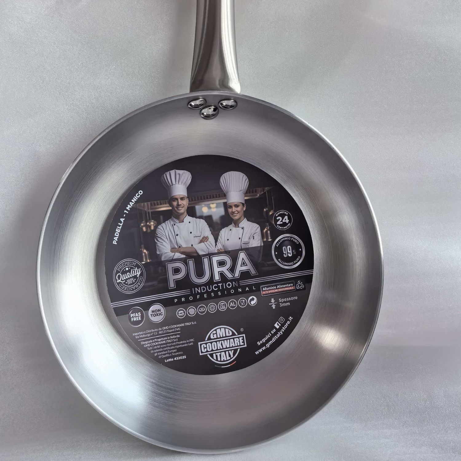 Una padella d'argento con un adesivo promozionale rotondo con due chef e la scritta Pura Induction.