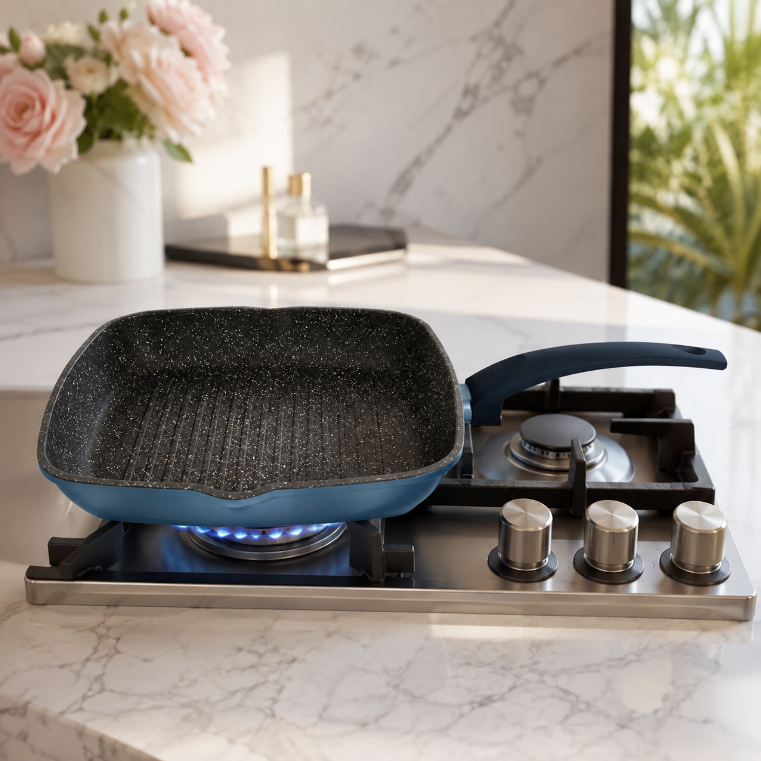 Padella grill quadrata blu su piano cottura a gas con fiori sullo sfondo.