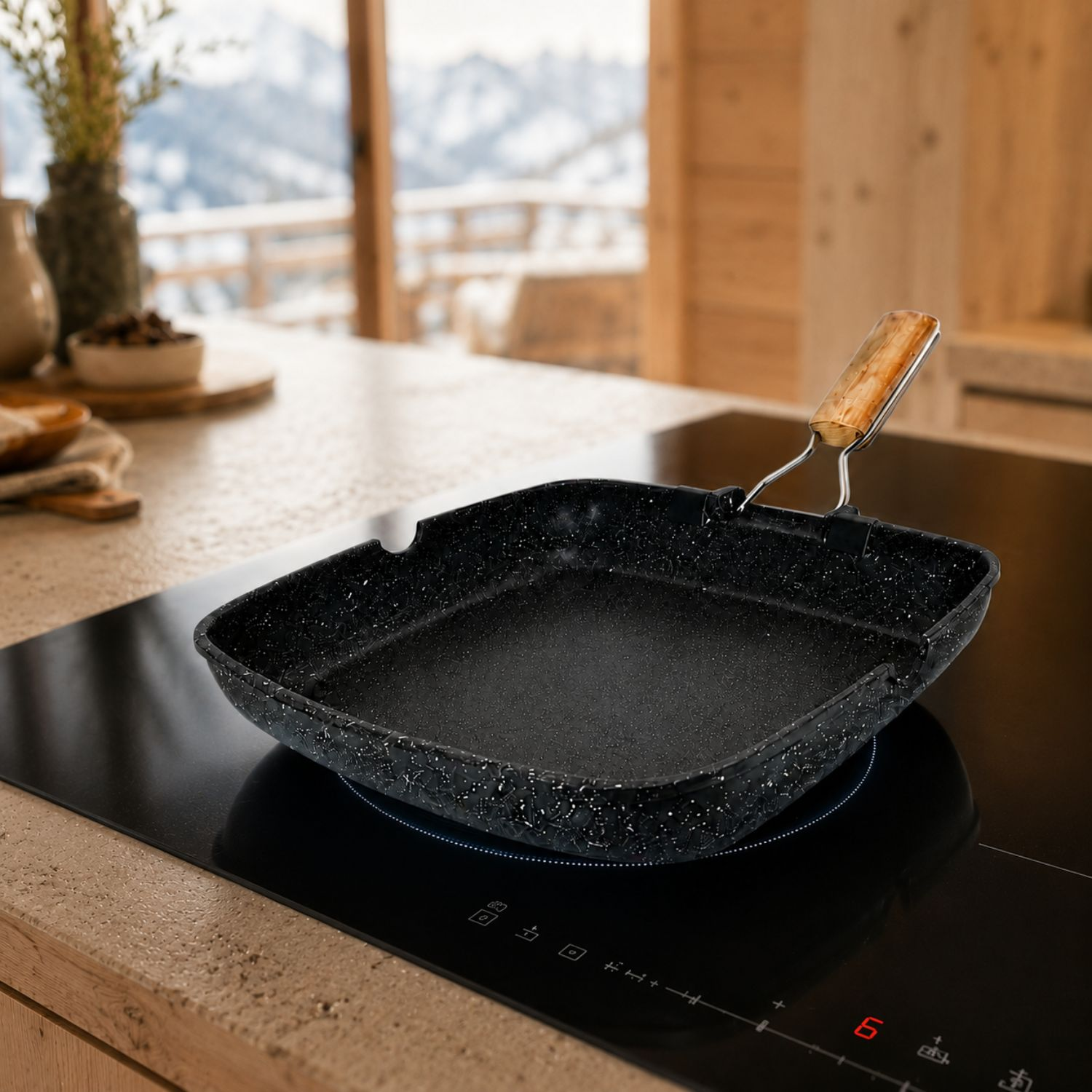 Una padella quadrata nera con manico in legno si trova su un piano cottura a induzione in una cucina in legno.