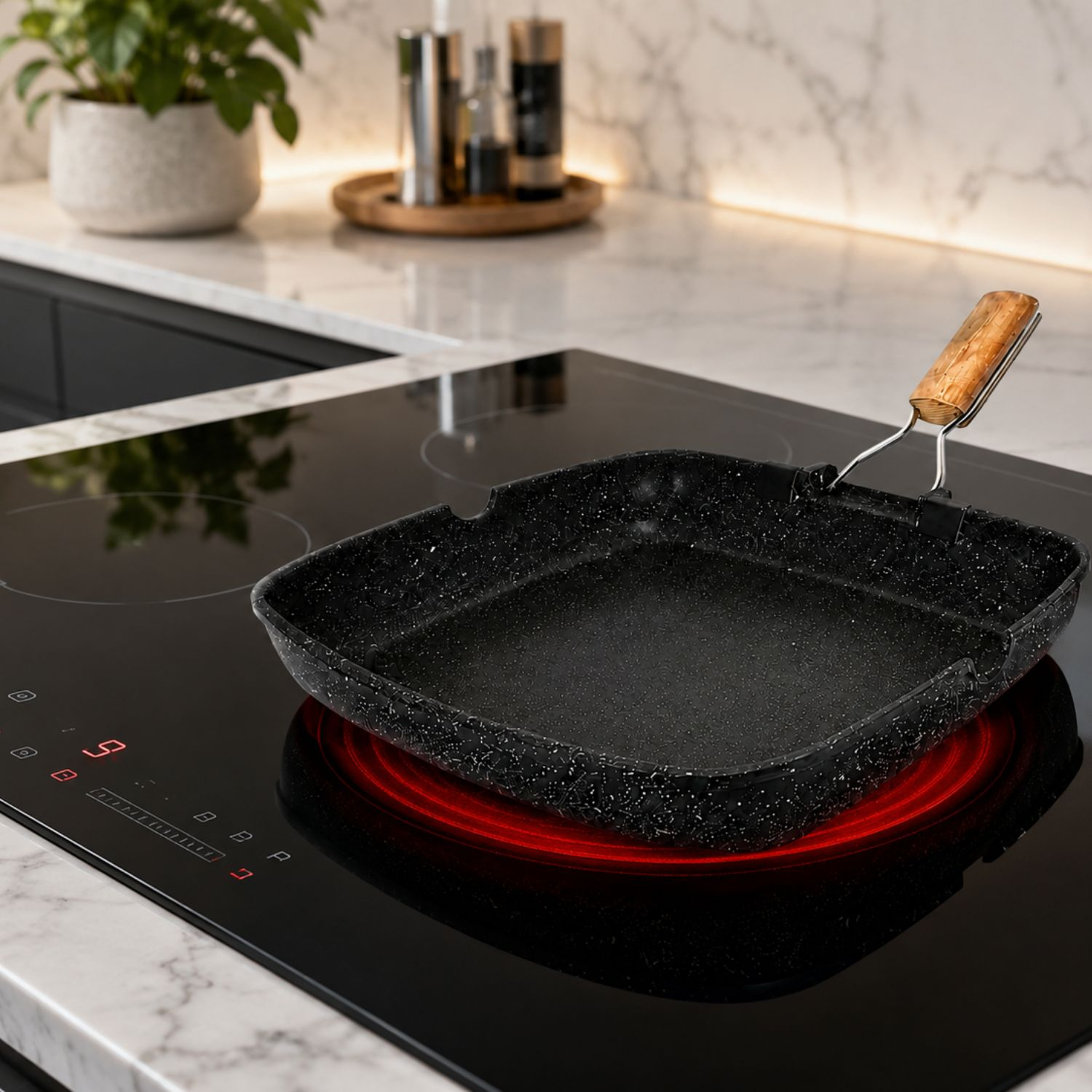 Una padella quadrata nera con manico in legno si trova su un piano cottura in ceramica rosso luminoso in una cucina moderna.