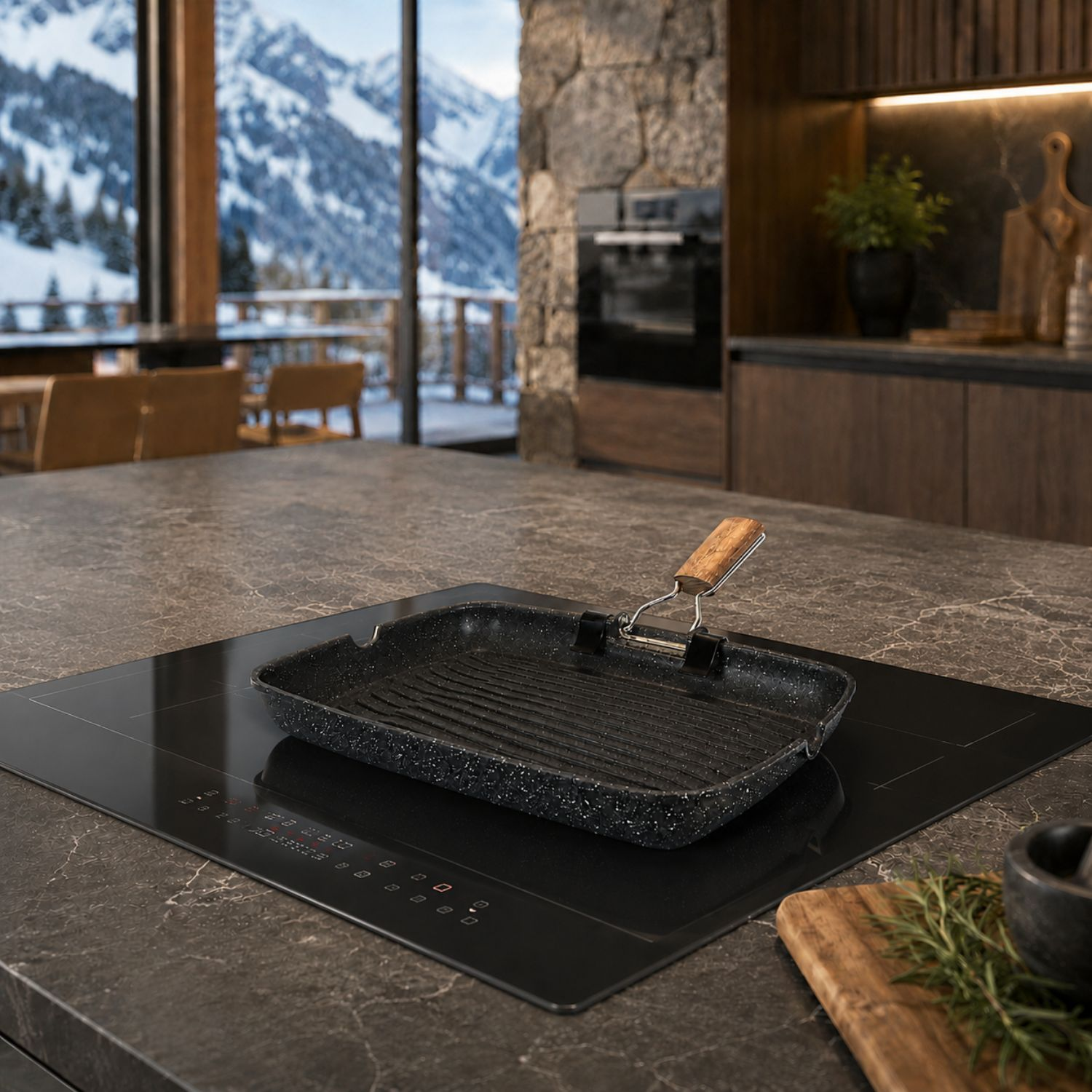 Una padella per griglia nera con manico in legno su un piano cottura a induzione in una cucina moderna con vista sulle montagne.