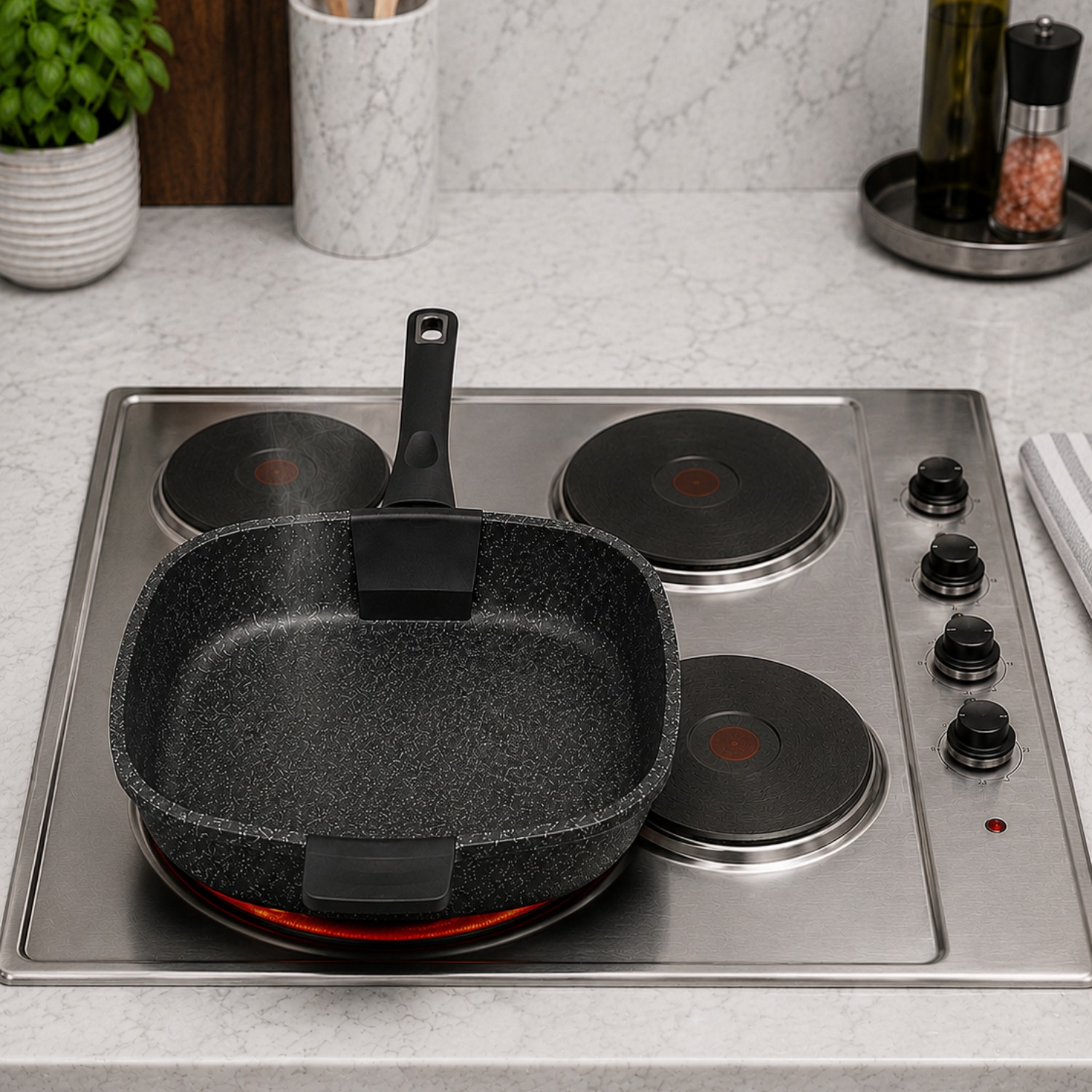 Una padella nera è poggiata su un piano cottura elettrico acceso in una cucina moderna.