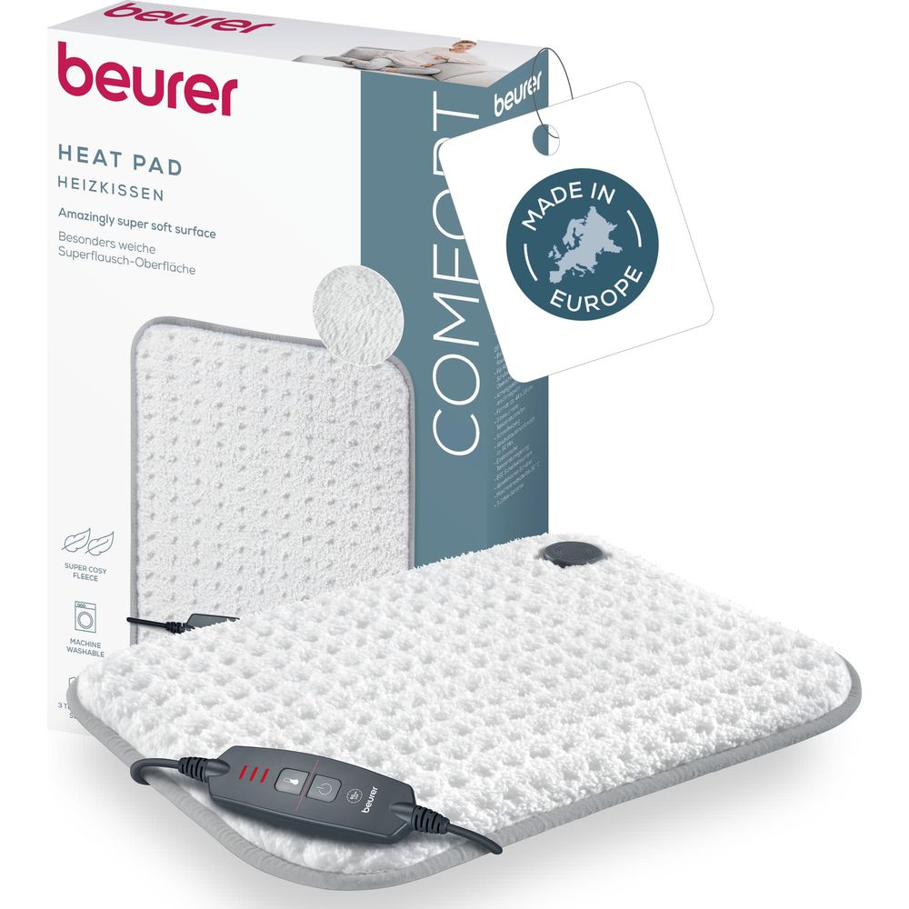 Beurer Heizkissen Comfort mit weißem, kuscheligem Bezug und Bedienelement vor der Verpackung.