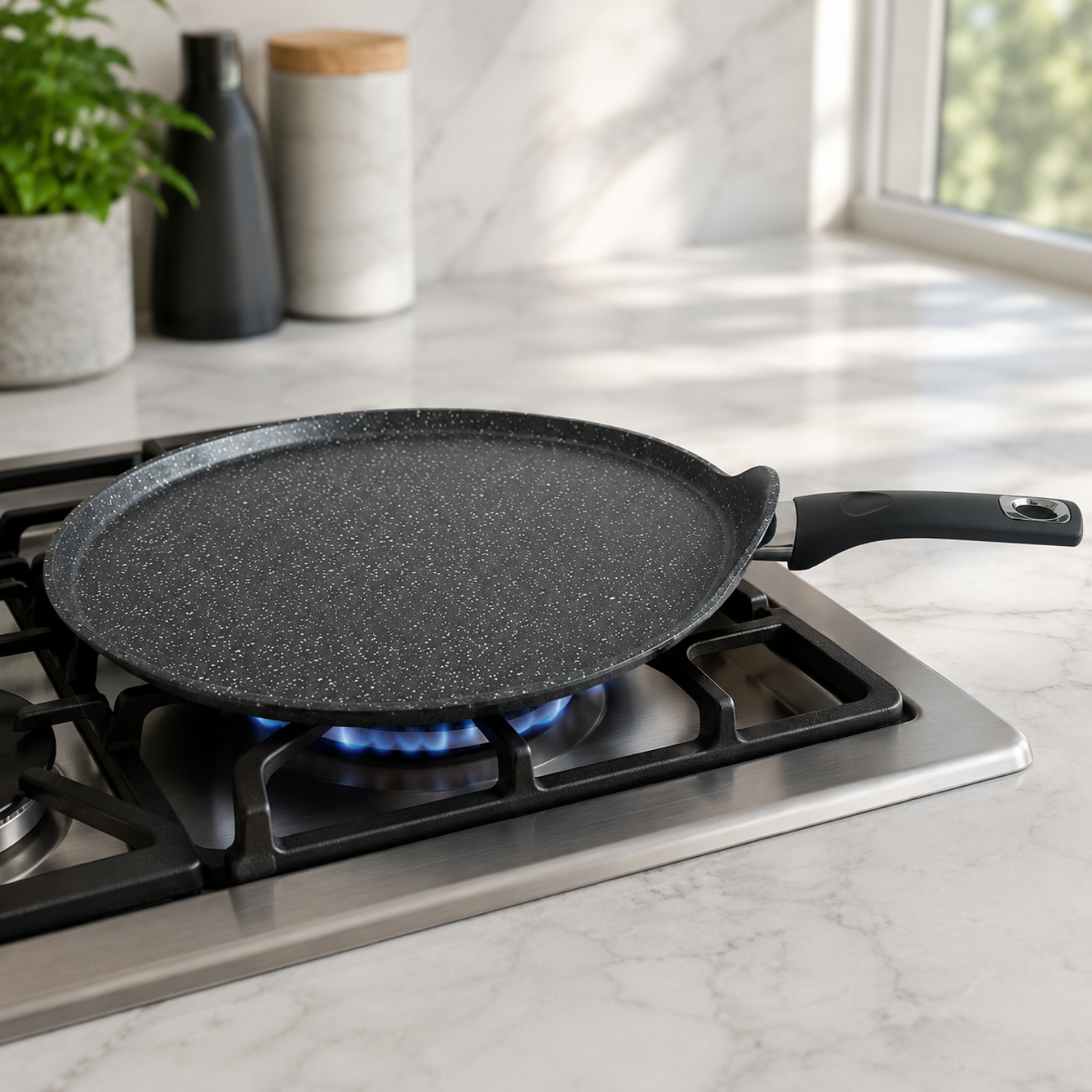 Una padella grigia screziata poggia su un piano cottura a gas acceso in cucina.