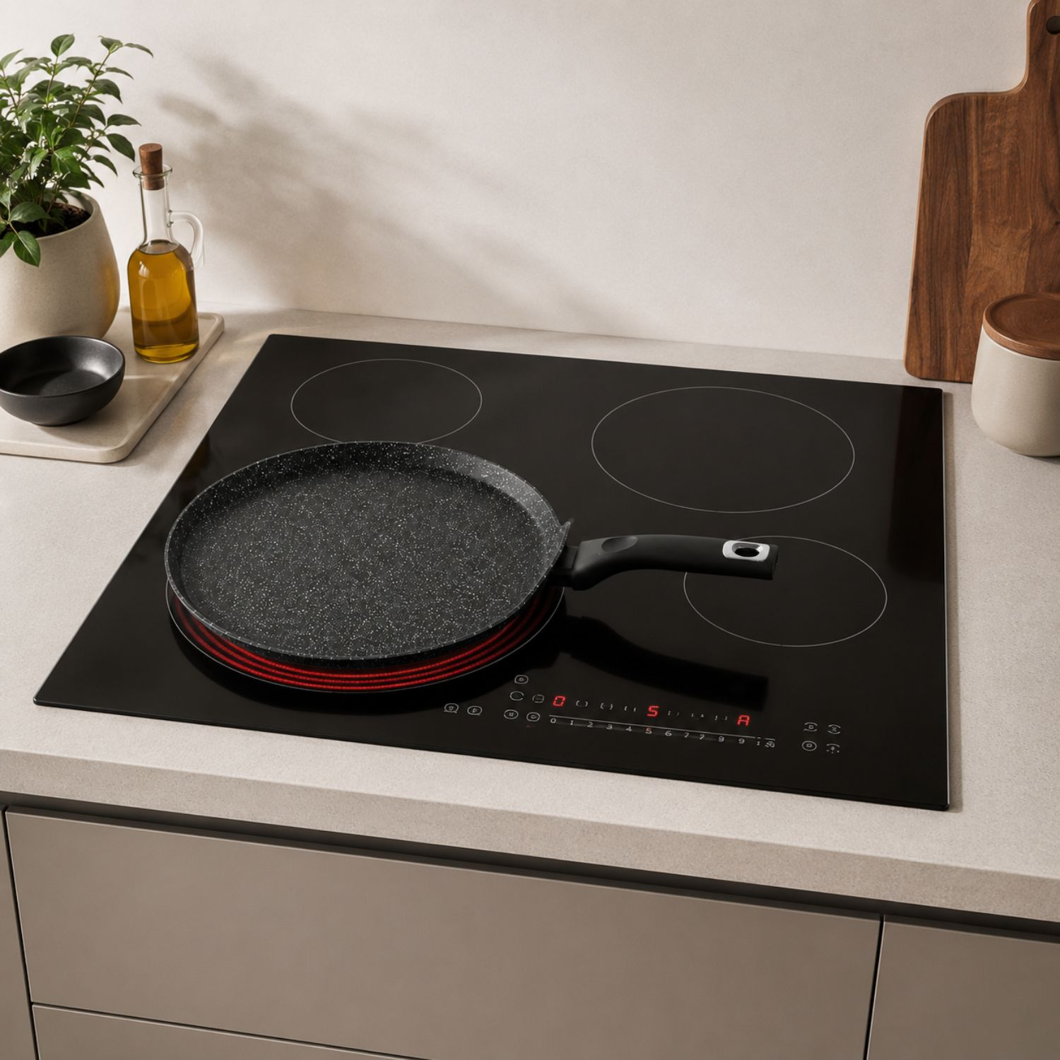 Una padella nera poggia su un piano cottura a induzione illuminato in una cucina moderna.