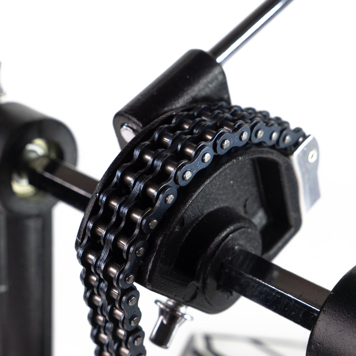 Nahaufnahme eines doppelten Fahrradketten-Antriebsmechanismus an einem Metallrahmen, vor weißem Hintergrund.