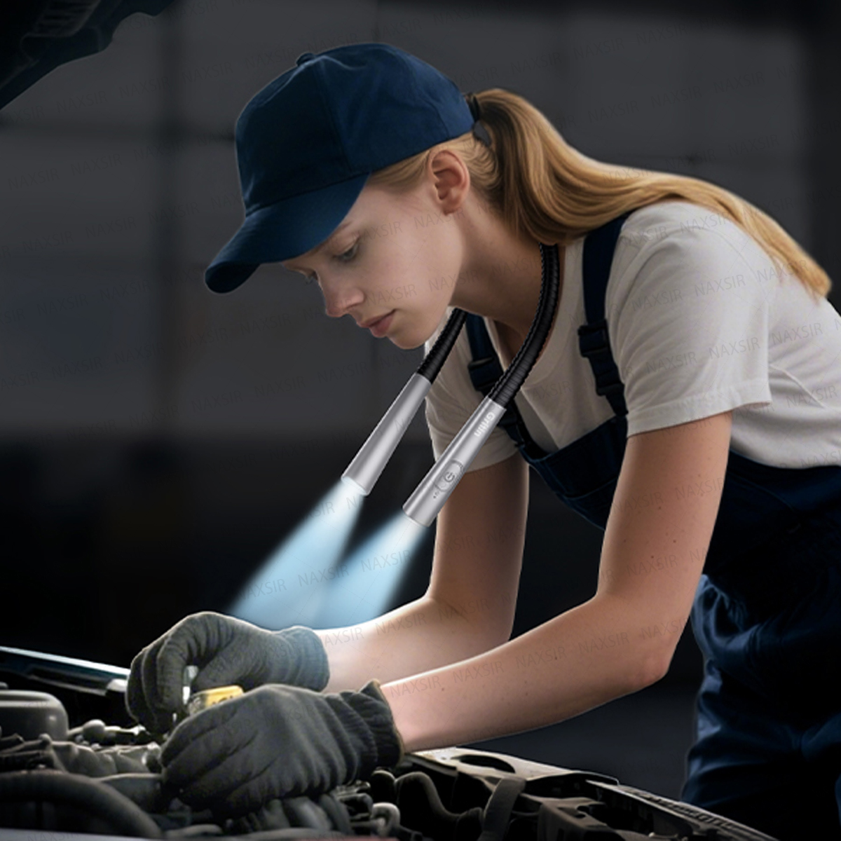 Eine Frau mit Mütze und Latzhose nutzt eine Nackenleuchte, um bei der Arbeit einen Motor zu beleuchten.