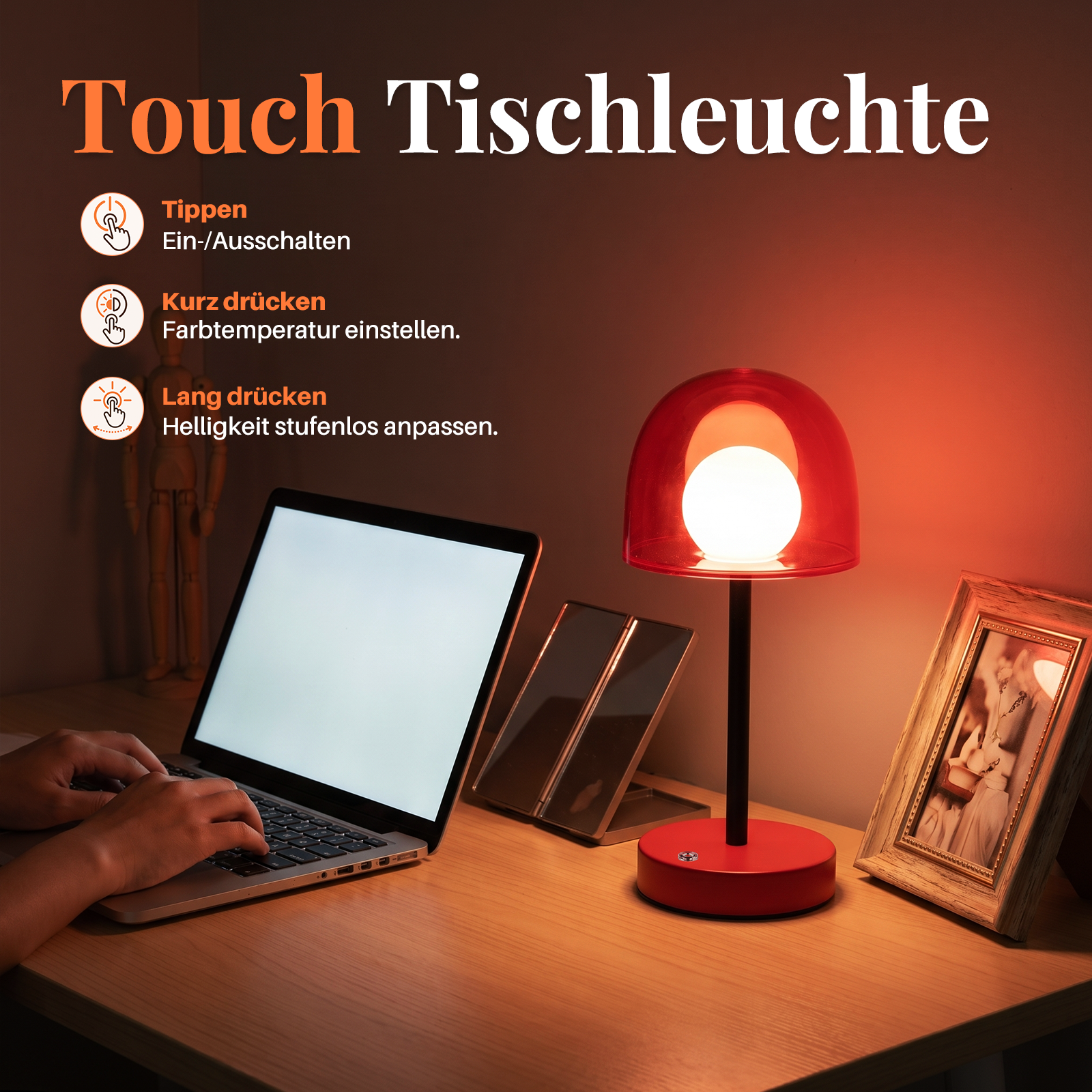 Una lámpara de mesa táctil roja sobre un escritorio con una computadora portátil, un espejo y un marco.