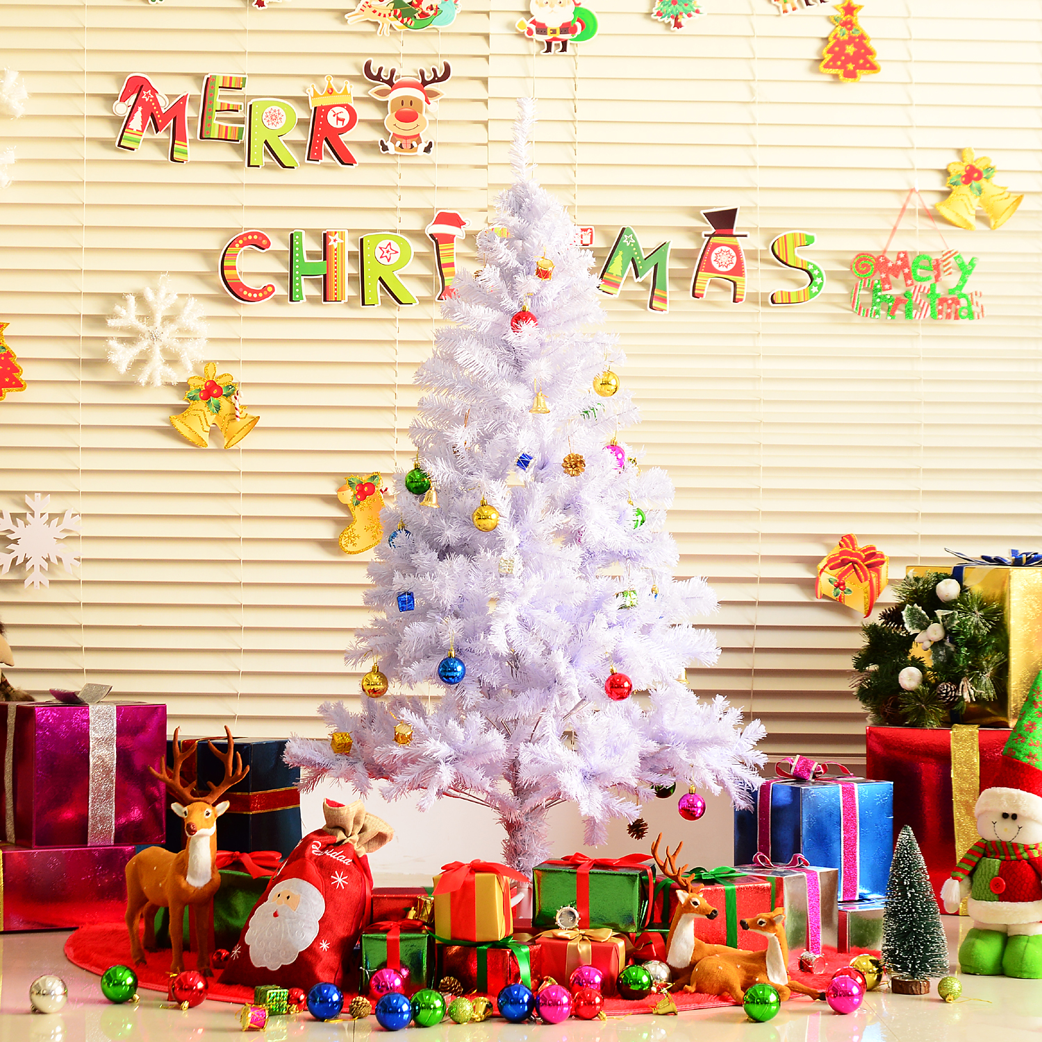 Un árbol de Navidad blanco decorado con adornos coloridos, rodeado de regalos y decoraciones navideñas.