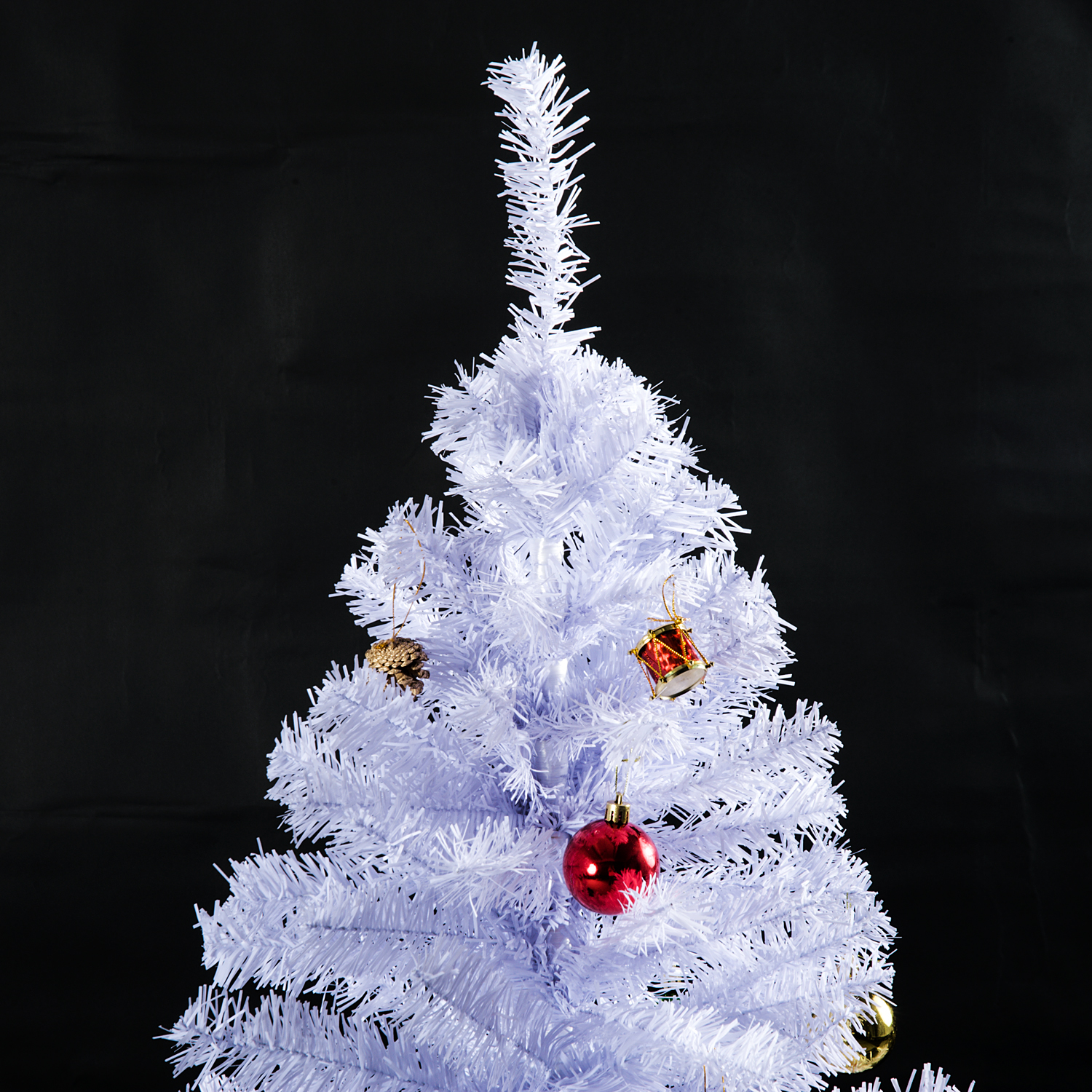 Un árbol de Navidad blanco con adornos rojos y dorados sobre fondo negro.