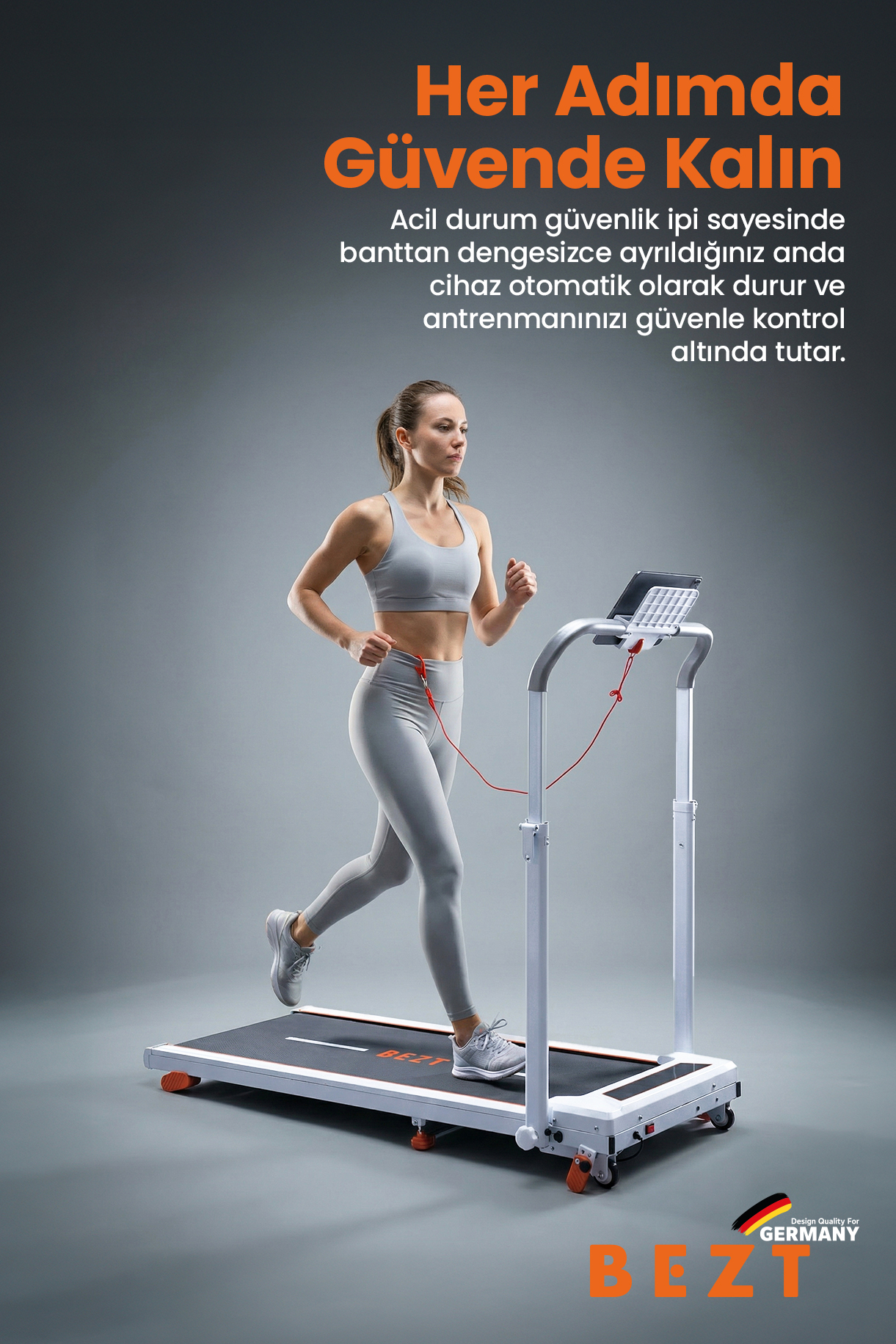 Gri spor kıyafetli bir kadın, güvenlik ipi bağlı beyaz bir koşu bandında koşuyor.