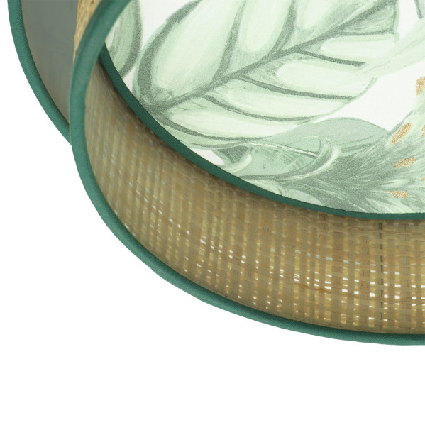 Pantalla redonda de bambú tejido con borde verde y diseño de hojas tropicales verde claro en el interior.