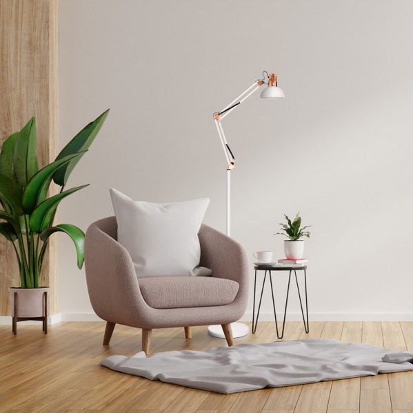 Un espacio acogedor con un sillón rosa, una lámpara de pie moderna y una planta grande.