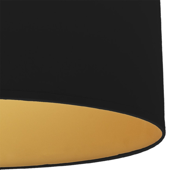 Una pantalla de lámpara negra con interior dorado sobre fondo blanco.