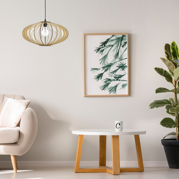 Sala con sillón beige, mesa de madera con taza, cuadro de plantas enmarcado, lámpara colgante y planta alta en maceta.