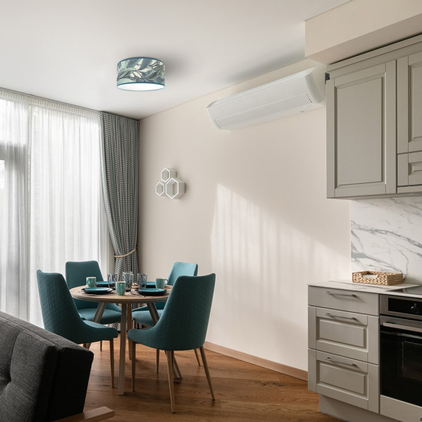 Cocina moderna con mesa de madera, sillas turquesas, armarios beiges, aire acondicionado y lámpara de techo.