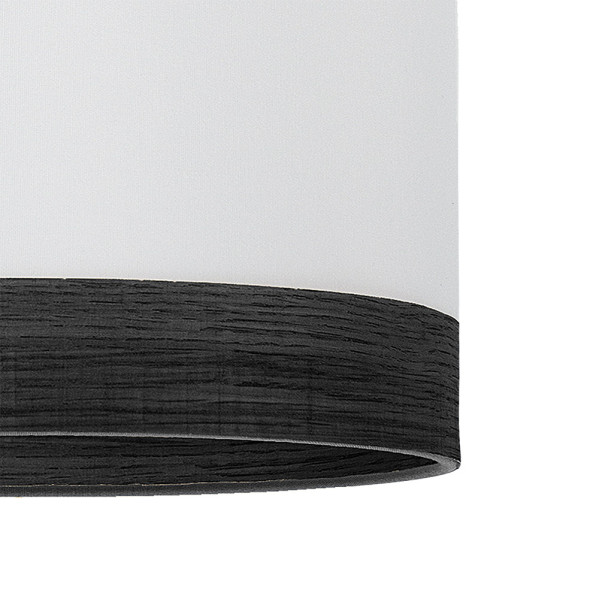 Una pantalla de lámpara cilíndrica con tela blanca arriba y un anillo de madera oscura abajo sobre fondo blanco.