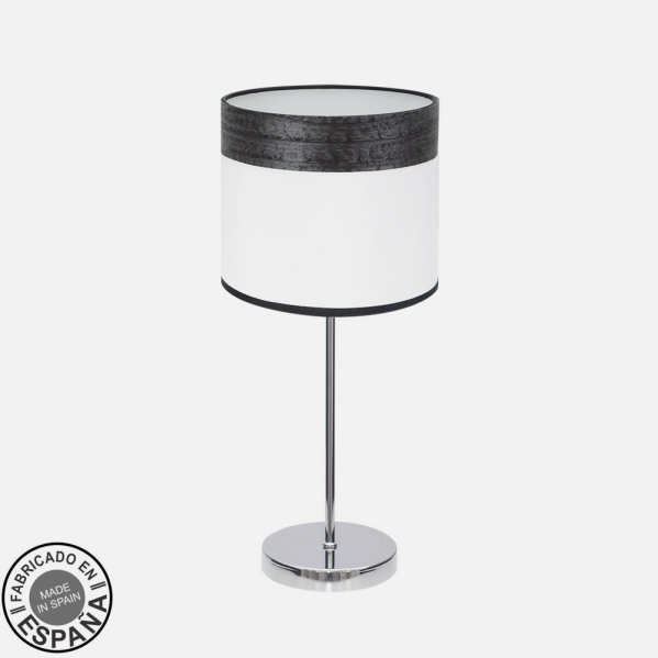 Lámpara de mesa con base cromada y pantalla cilíndrica en blanco y negro texturizado sobre fondo claro.