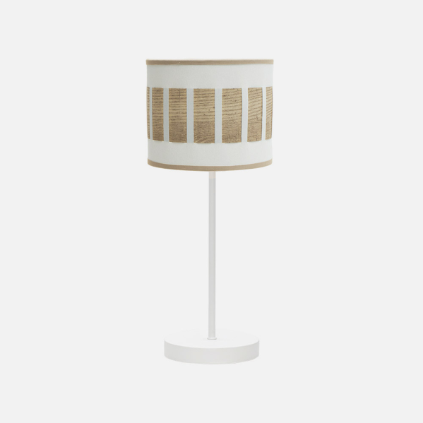 Una lámpara de mesa blanca con pantalla cilíndrica de tela blanca y tiras de madera marrón sobre fondo blanco.