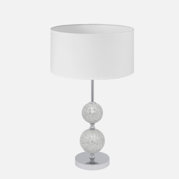 Una lámpara de mesa elegante con pantalla blanca y dos esferas de vidrio de mosaico plateado.