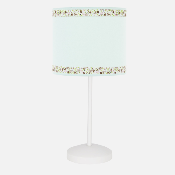 Una lámpara de mesa con pantalla azul claro con motivos florales arriba y abajo, sobre soporte blanco.