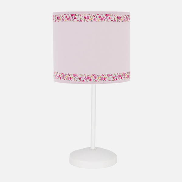 Una lámpara de noche blanca con una pantalla rosa cilíndrica y cenefa floral.