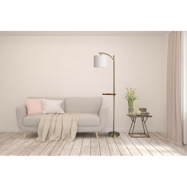 Una sala acogedora con un sofá gris claro, cojines, lámpara de pie con mesita y una mesita auxiliar.