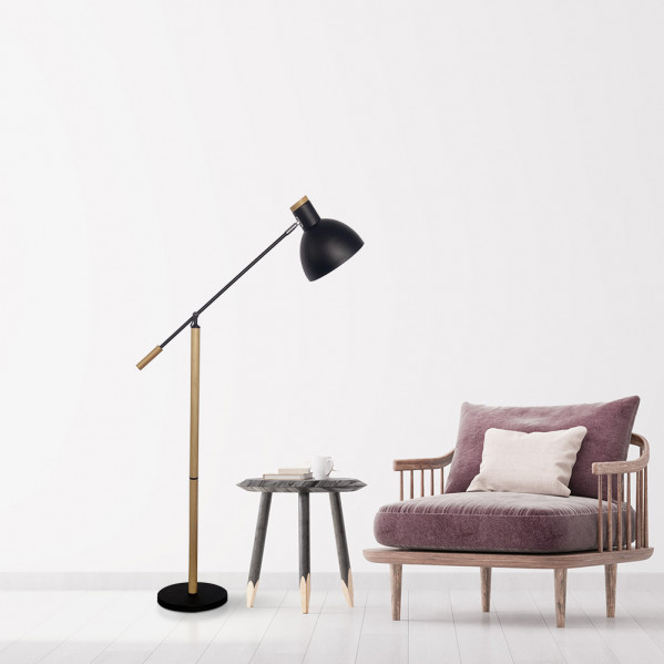 Una lámpara de pie negra con detalles en madera, una mesita y un sillón morado se encuentran junto a una pared blanca.