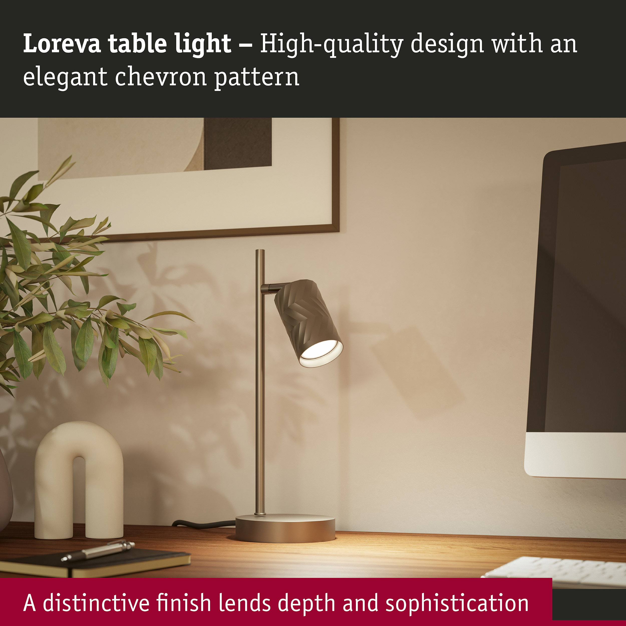 Loreva-Tischlampe mit Chevron-Muster auf Holztisch neben Pflanze, Dekor und Computer.