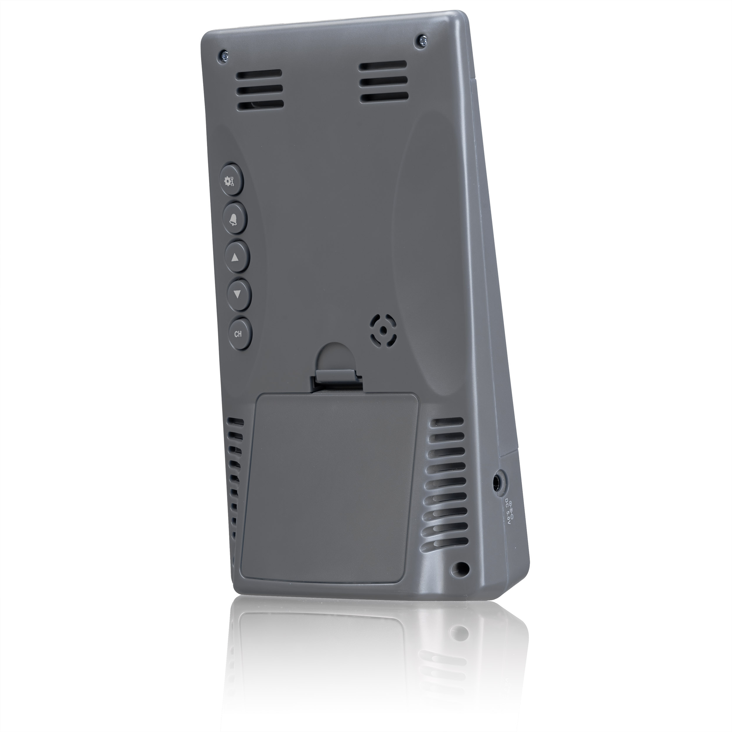 Parte trasera de un dispositivo electrónico gris con altavoces, botones de control y compartimento de pilas.
