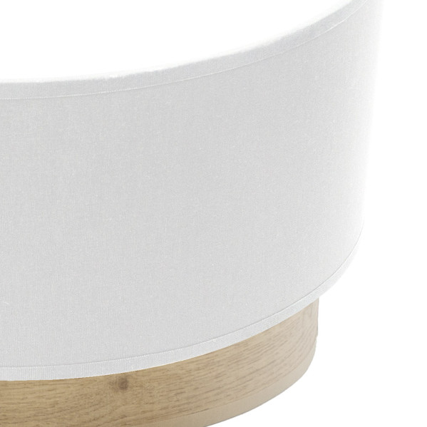 Una pantalla de lámpara cilíndrica blanca descansa sobre una base de madera plana.