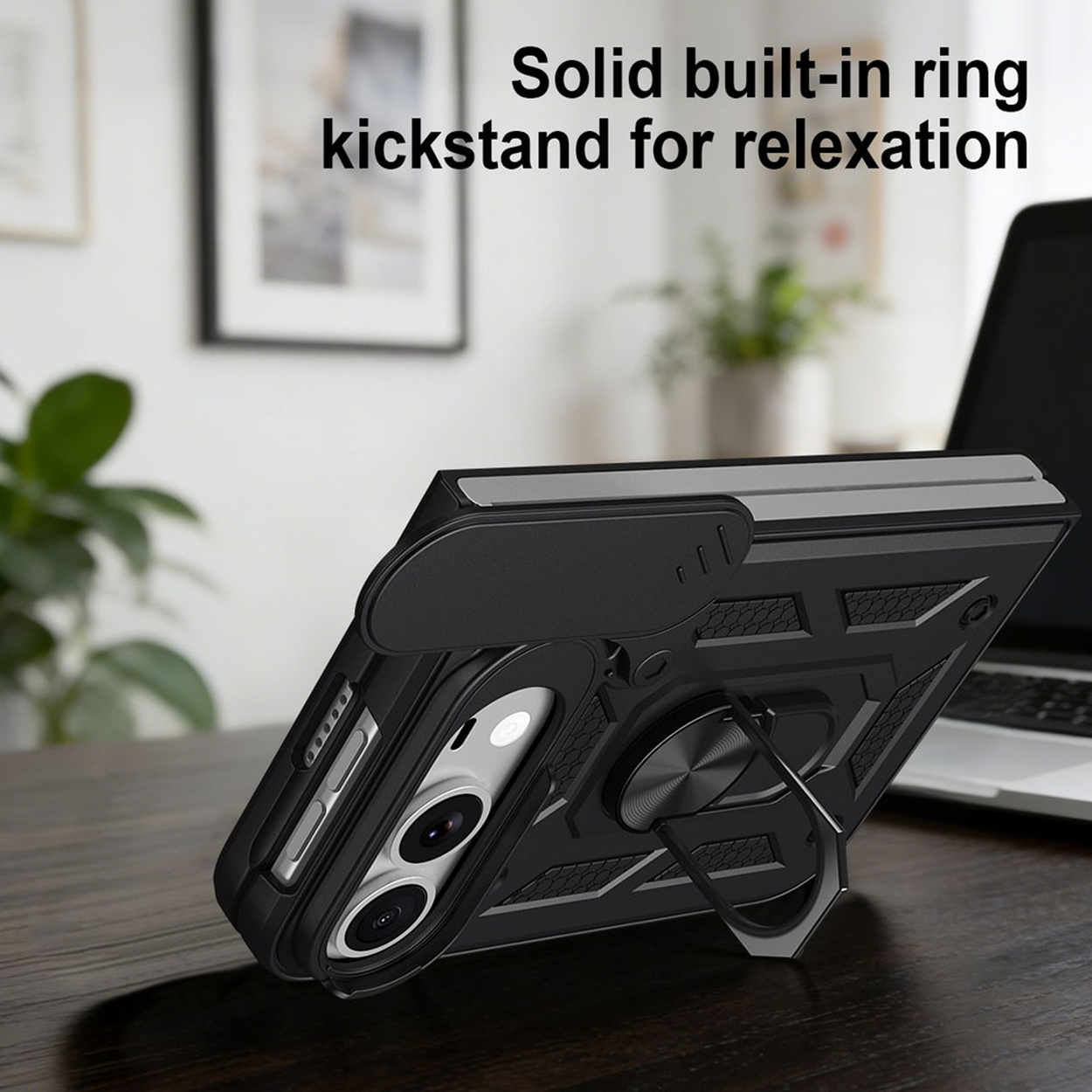 Schwarze Handyhülle mit integriertem Ringständer auf Holztisch vor Laptop.
