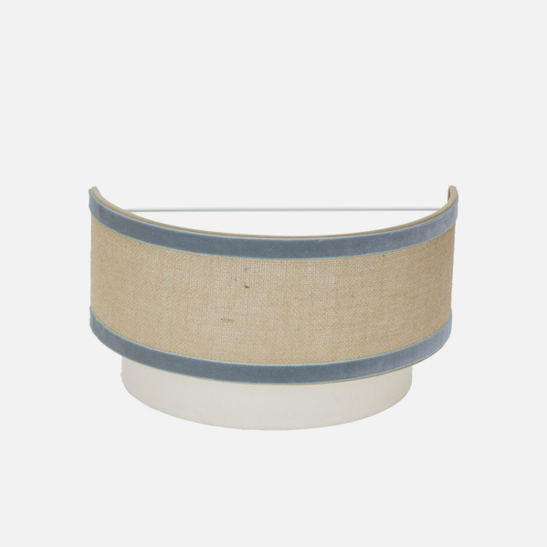 Lámpara de pared con pantalla de tela beige y ribete de terciopelo azul.