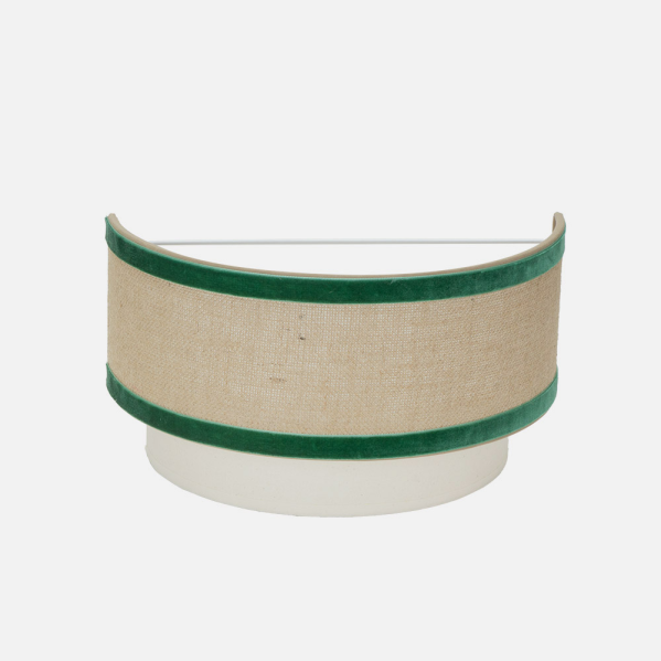 Lámpara de pared semicircular beis con ribete de terciopelo verde sobre fondo claro.