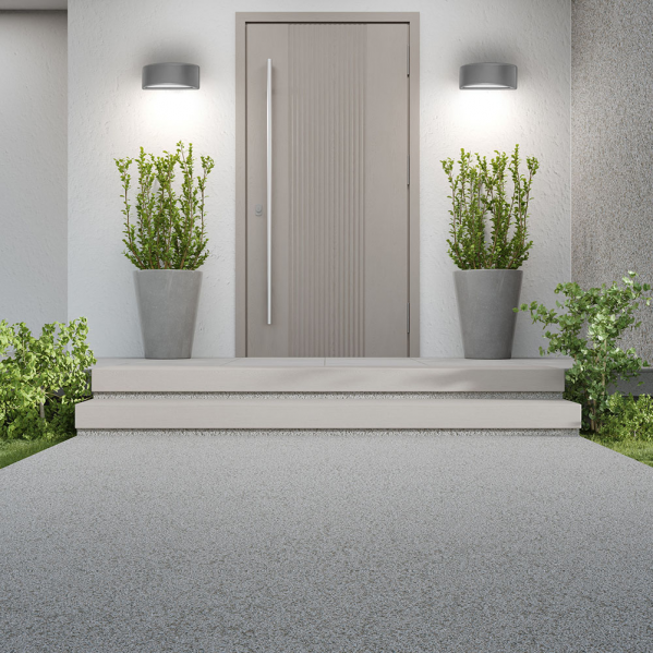 Puerta de entrada moderna con dos macetas grises y apliques de pared iluminados en la fachada blanca.