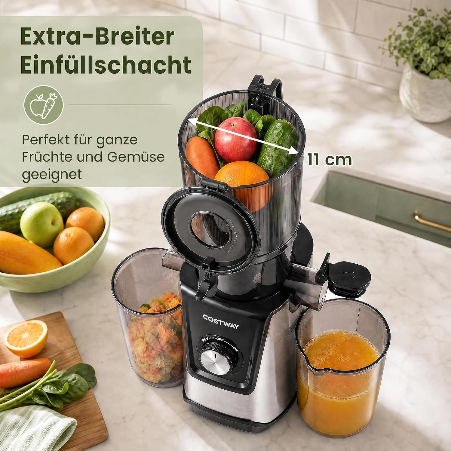 Ein schwarzer und silberner Entsafter mit 11 cm breitem Einfüllschacht für ganzes Obst und Gemüse auf einer Küchenzeile.