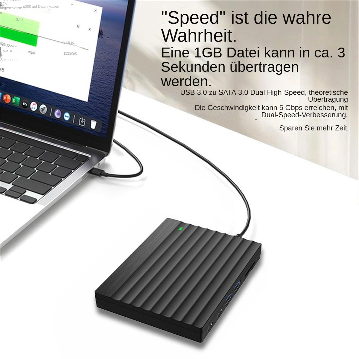 Eine schwarze externe Festplatte, per Kabel mit einem Laptop auf einem weißem Schreibtisch verbunden, mit Werbetext.