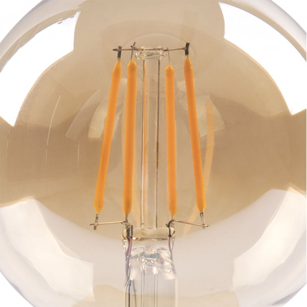 Primer plano de una bombilla con cuatro filamentos LED naranjas verticales dentro de un cristal redondo.