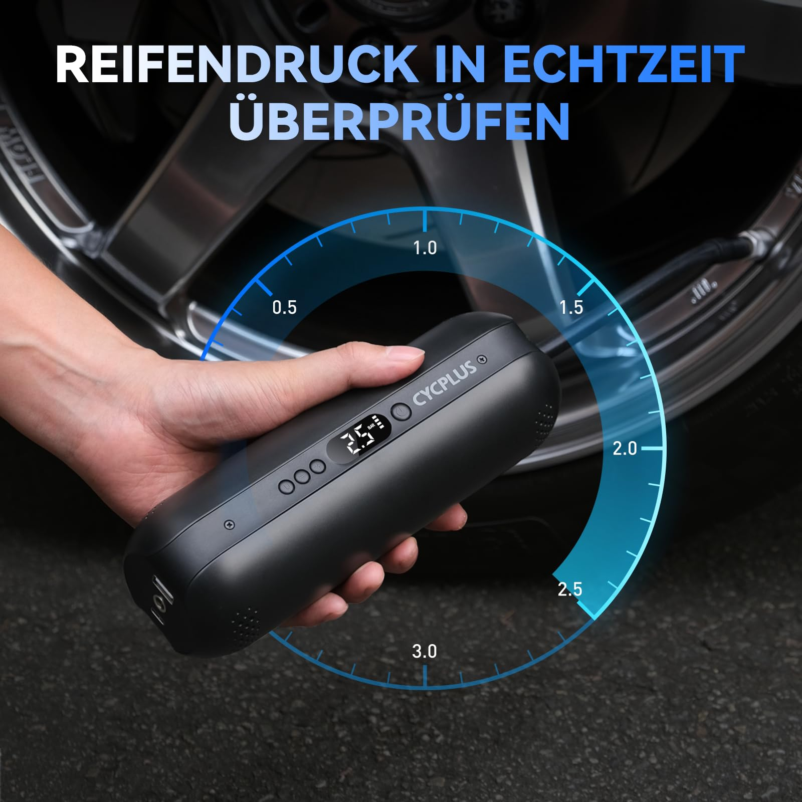 Eine Hand hält eine schwarze Cycplus Luftpumpe vor einem Autoreifen mit digitaler Druckanzeige.