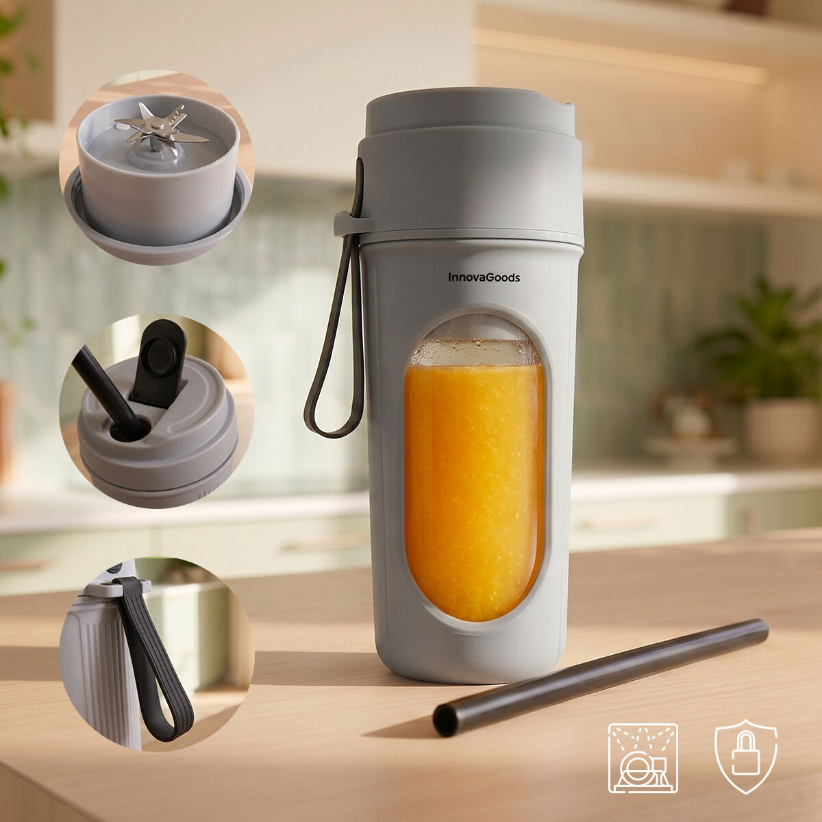 Frullatore portatile grigio con succo d'arancia e accessori su tavolo.