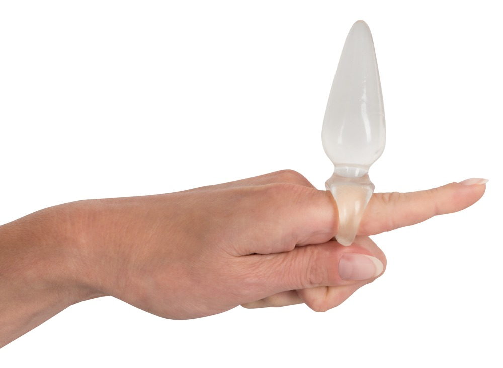 Eine Hand trägt einen klaren, spitzen Glasring an ihrem Zeigefinger, isoliert auf weißem Hintergrund.