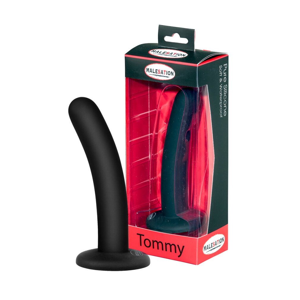 Ein schwarzer, abgerundeter Silikon-Dildo steht neben seiner rot-schwarzen Verpackung mit der Aufschrift Tommy.