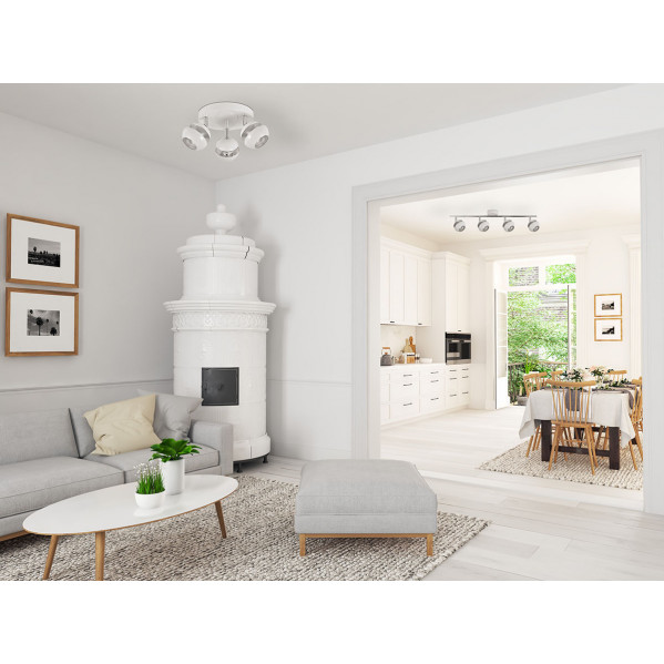 Salón con sofá gris, estufa de azulejos blancos y vista a cocina luminosa con comedor.